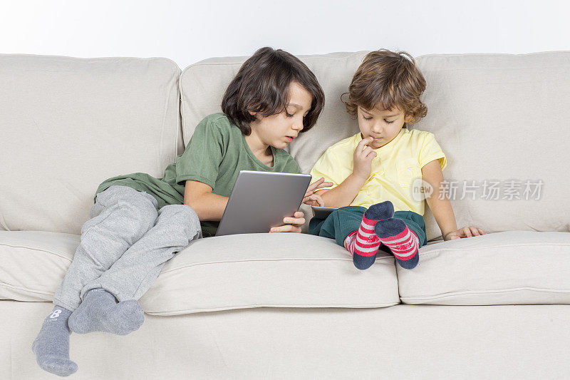 兄弟俩在沙发上玩平板电脑