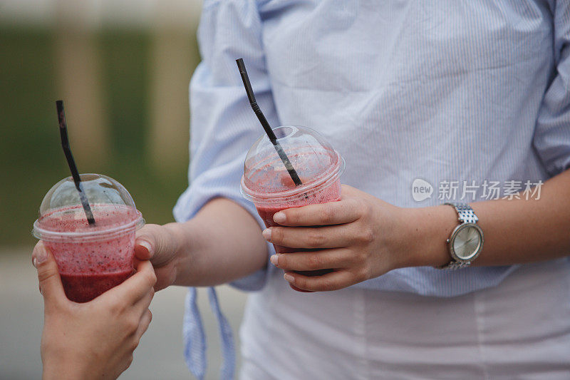 年轻女子给她的朋友一杯清凉的奶昔后，会见她