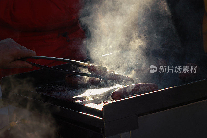 肉和香肠在街上的大烤架上烤着