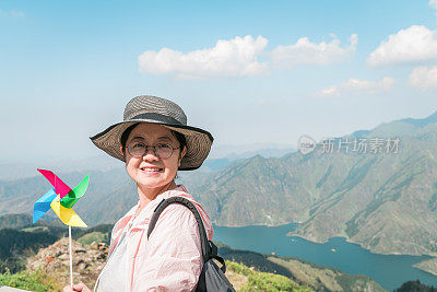 美丽的女人拿着风车玩具在天山