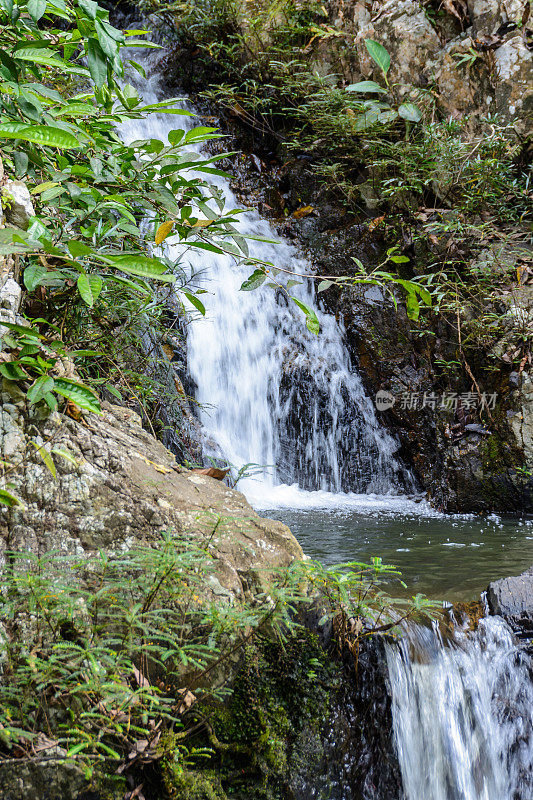 美丽的瀑布，急流和山涧在热带森林里，三亚市Yanoda公园。海南,中国。