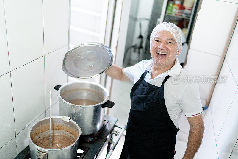 一个厨师在餐厅的工业厨房里煮豆子的肖像
