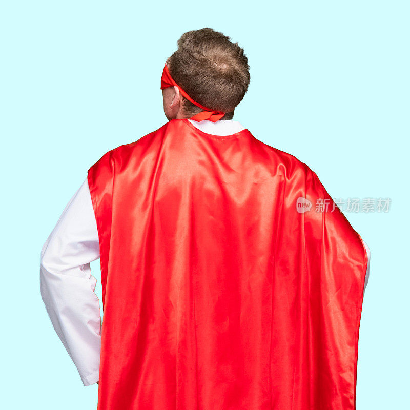 白人男性超级英雄穿着斗篷站在白色背景前