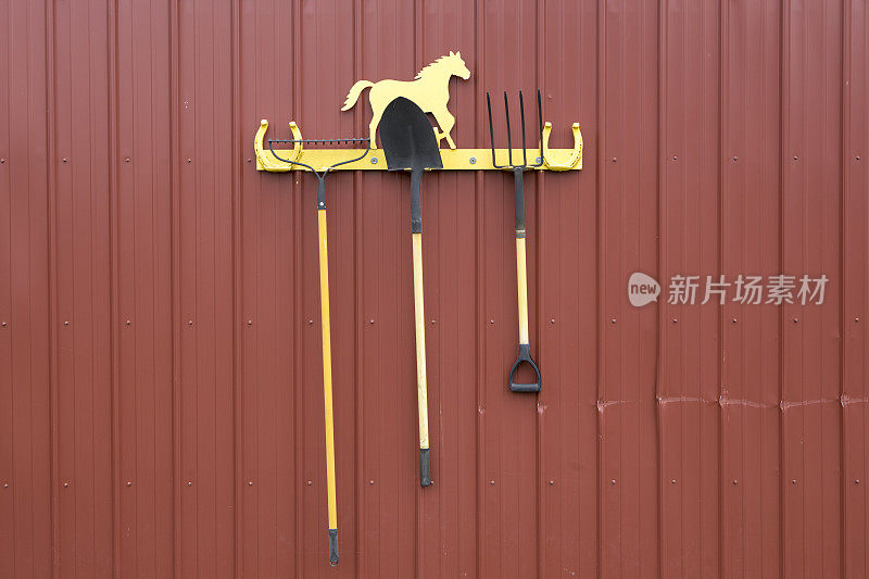 耙，铲子和干草叉放在架子上。