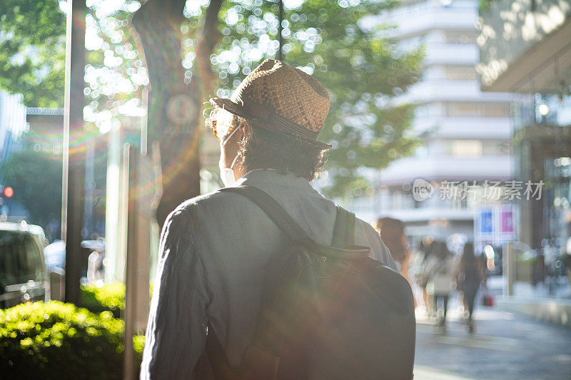 一名戴着面具的男子穿过东京的街道。