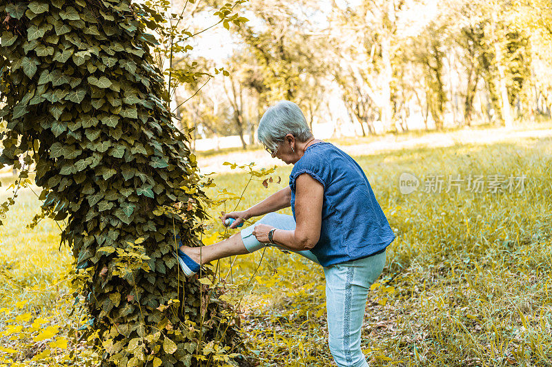 老妇人在公园里使用驱虫剂