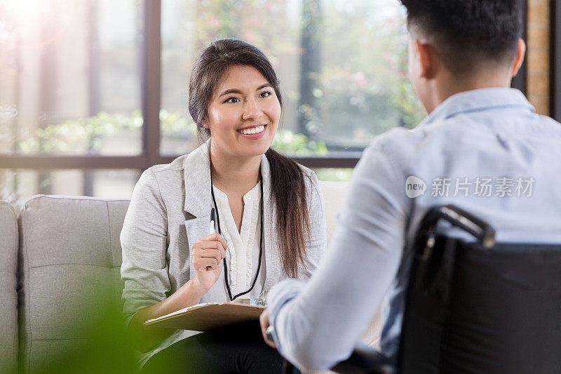 女性治疗师为坐轮椅的男人提供咨询