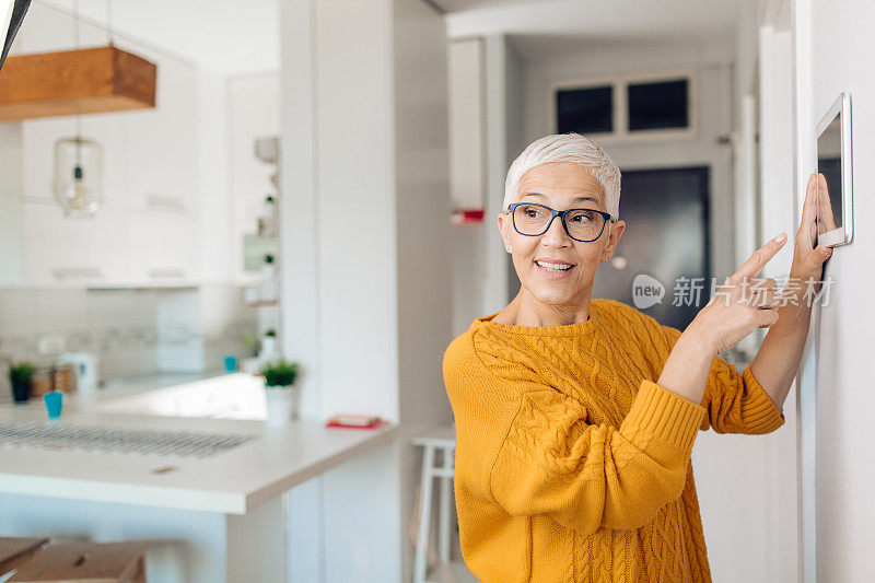 成熟的女人在调整智能家居系统