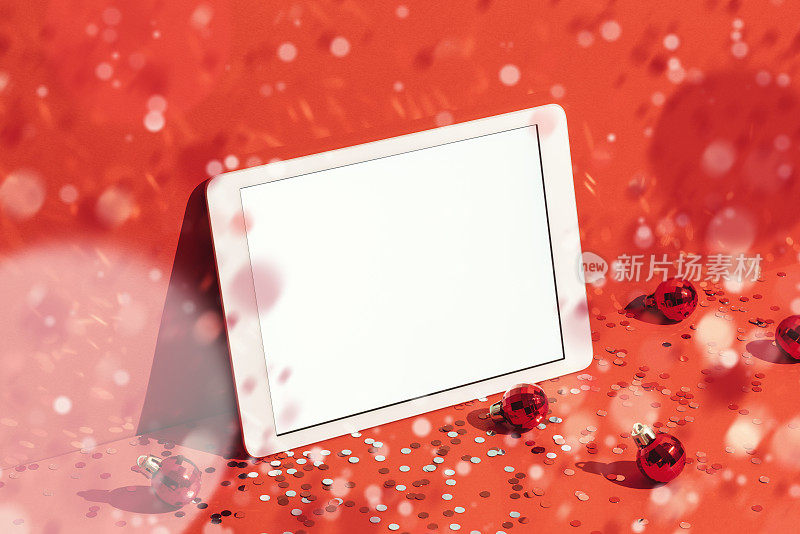 数字平板模型，红色圣诞背景下的纸屑雨模板
