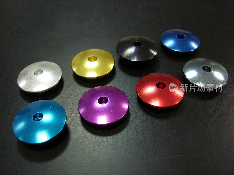 蓝色，红色，银色，金色，紫色铝制零件孤立在黑色背景上，CNC零件