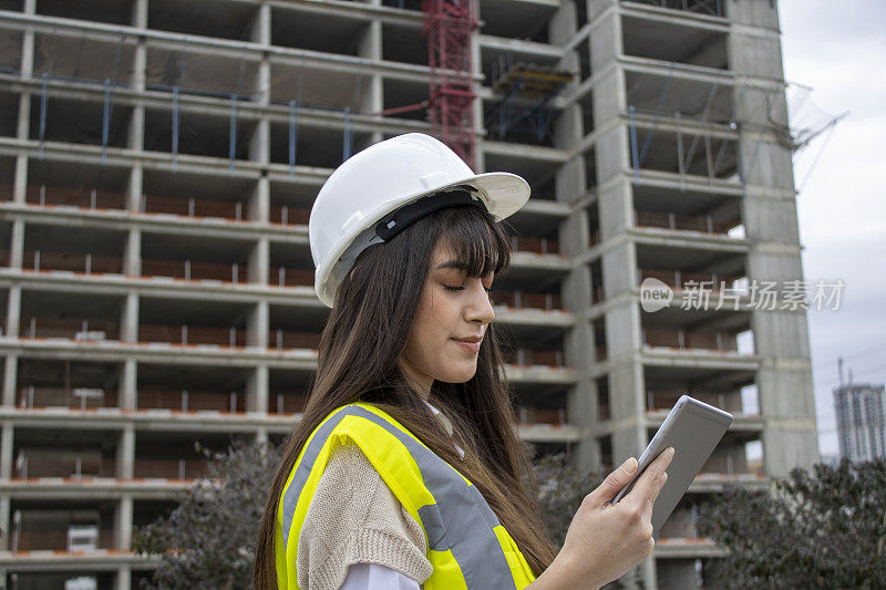 女建筑师在建筑工地与数字平板电脑