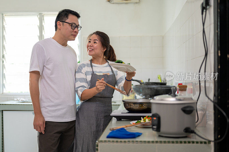 快乐的亚洲夫妇在厨房做饭