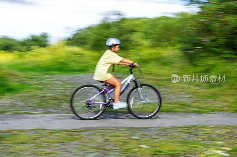 12岁的女孩在乡下骑自行车