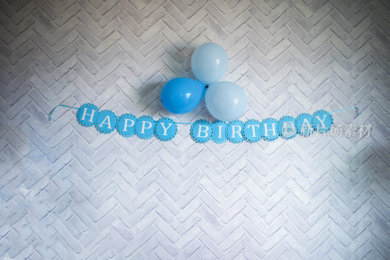 在灰色背景上漂浮的蓝色气球上祝你生日快乐