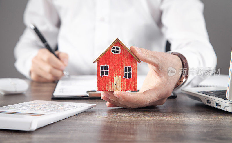 房地产中介持有房屋模型并签订合同。