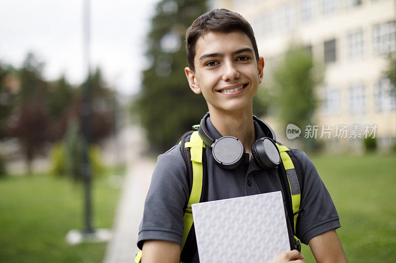 一个微笑的少年在学校前面的肖像