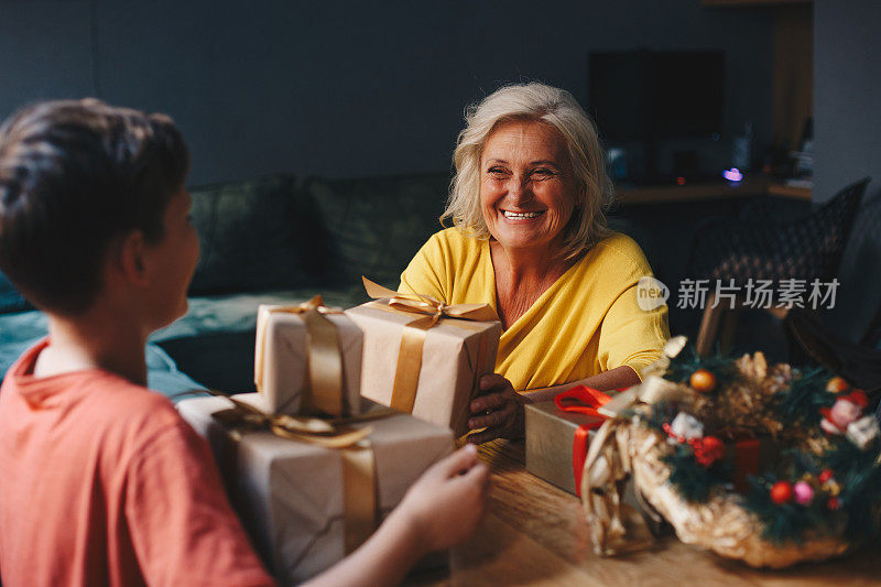 礼物差不多准备好了。奶奶正在和她的孙子打包新年礼物。