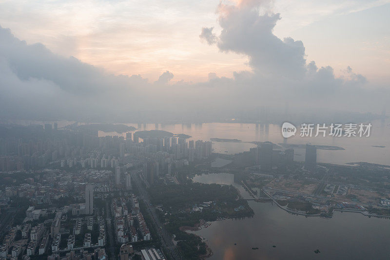 鸟瞰图的海滨城市天际线笼罩在雾和云