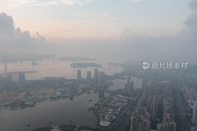 鸟瞰图的海滨城市天际线笼罩在雾和云