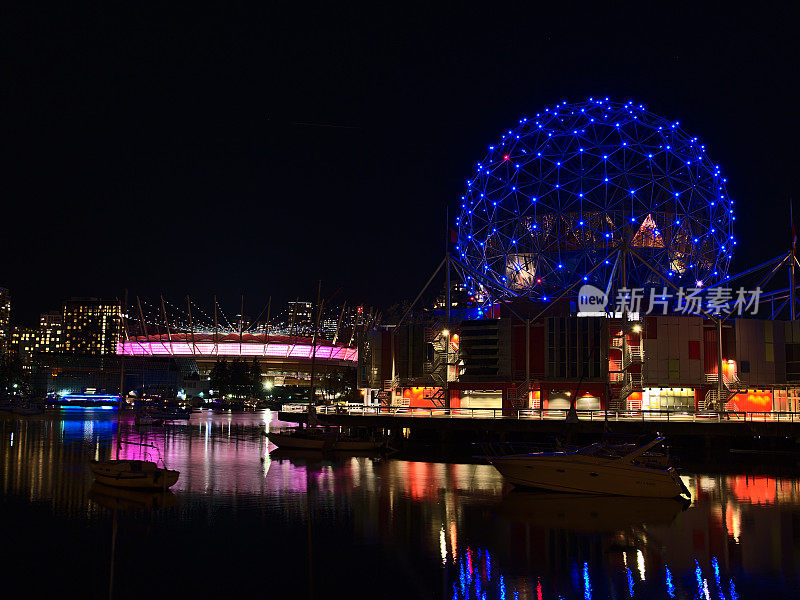 温哥华科学世界和BC广场体育场的夜景，照亮的天际线反映在福溪湾的平静的水。