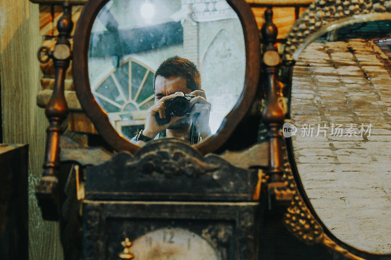 一名摄影师在古董店的镜子前拍照
