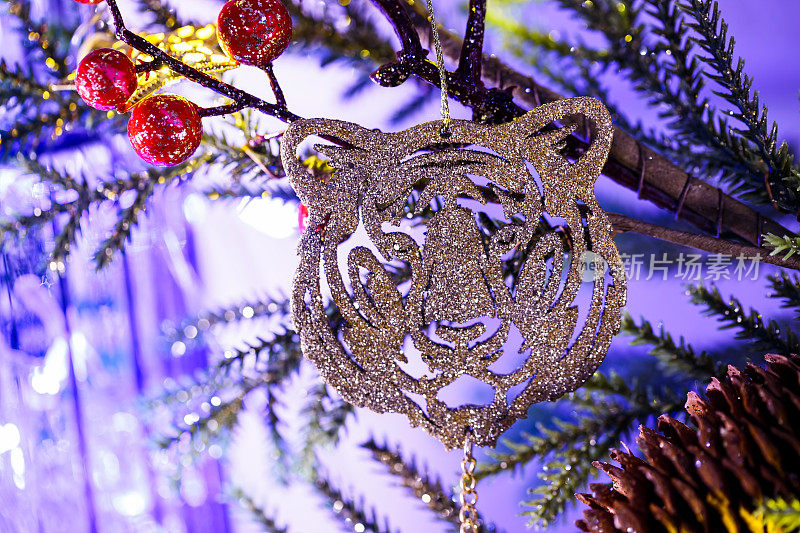 圣诞树玩具特写。一只银色老虎的嘴挂在装饰圣诞树的树枝上。年的象征