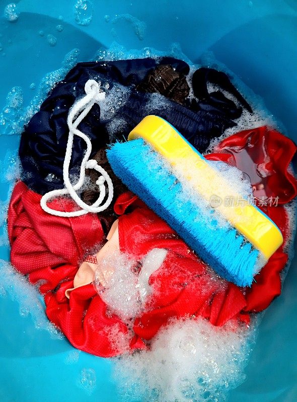 用蓝色的水桶洗衣服。