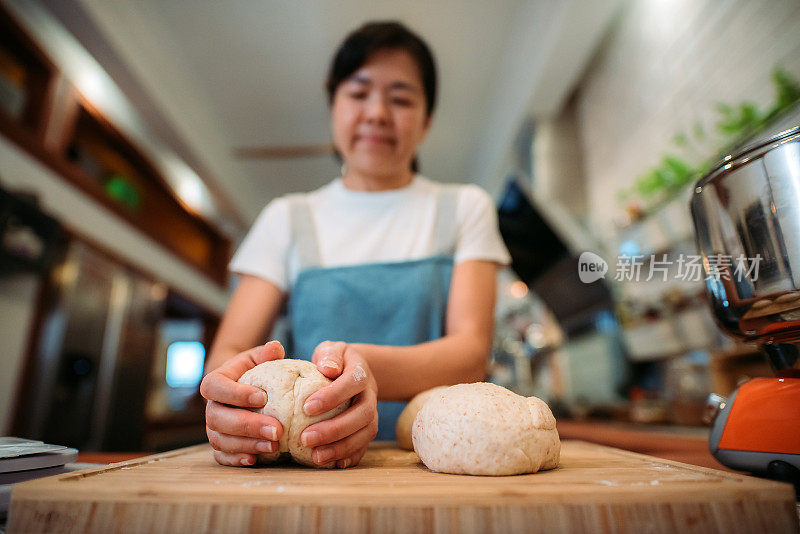 亚洲华人面包师在厨房准备生面团