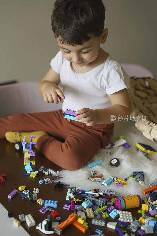 可爱的小男孩在餐桌上玩玩具，在家里