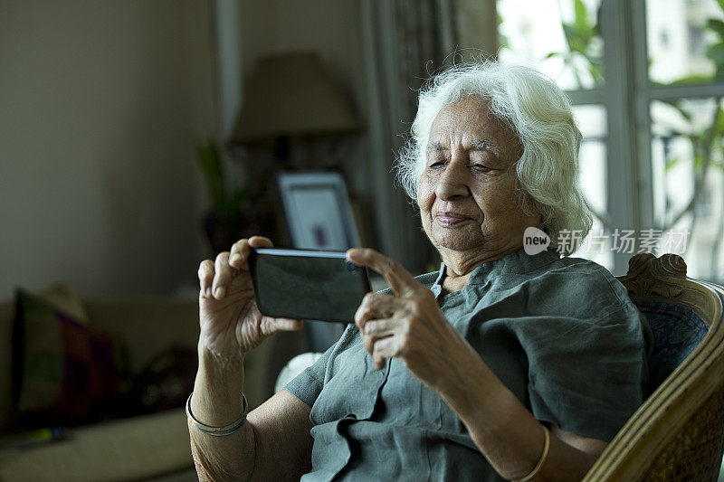 在家使用手机的老妇人