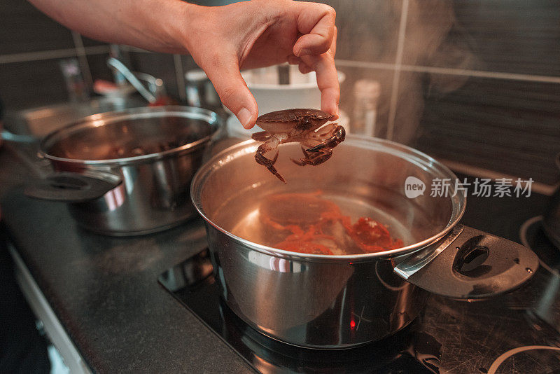 厨师在锅中加入新鲜的螃蟹