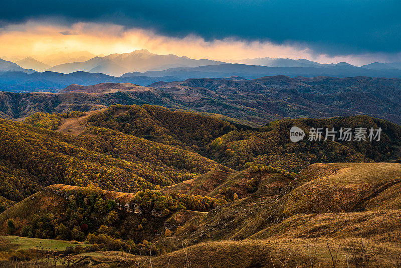 从俄罗斯厄尔布鲁斯地区的冈巴什山口，欣赏山脉山脊和山谷的壮丽日落