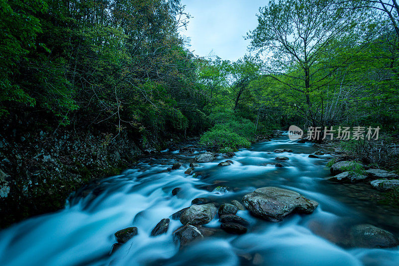 在黄昏时分，河流在山上急速流动。