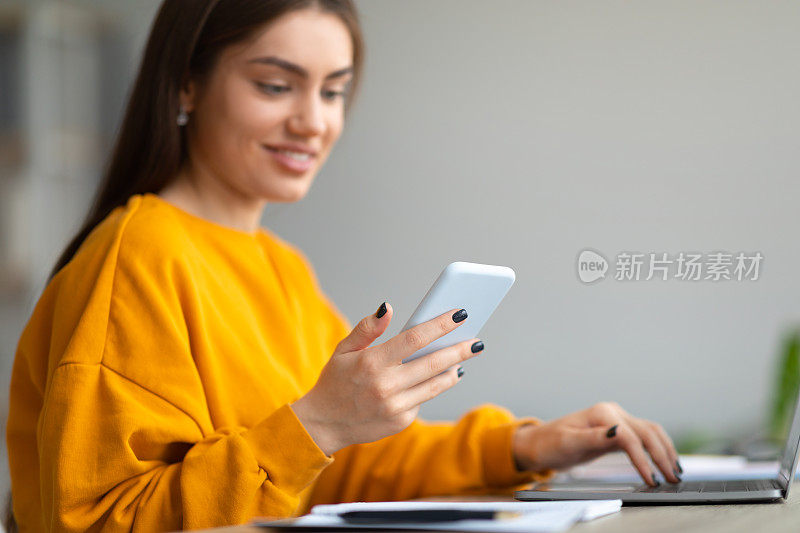 漂亮的年轻白人女性使用手机和笔记本电脑在线工作或在家学习，复制空间
