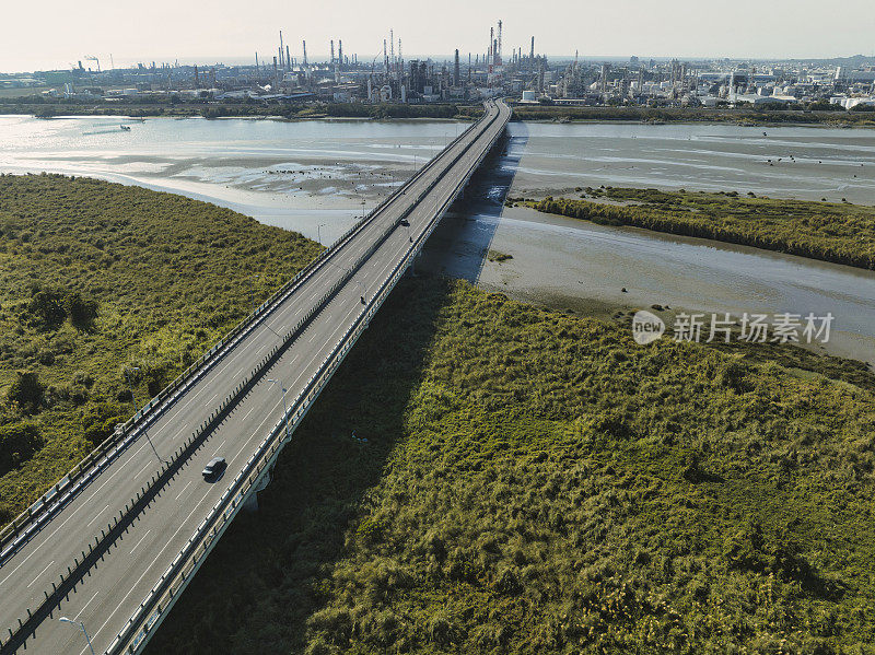 汽车在高速公路路口行驶的鸟瞰图。桥梁道路与绿色花园和树木相连接的建筑概念。