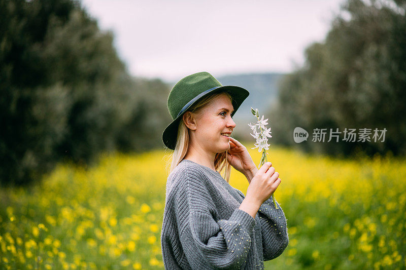 美丽的年轻女子手持春天的花朵