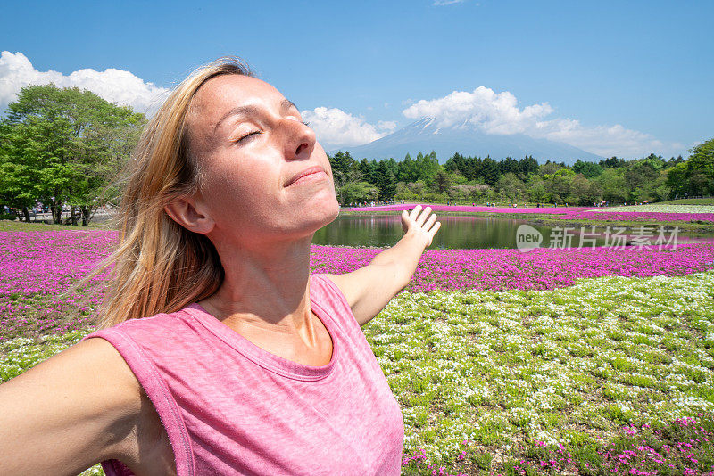 女人在日本旅行，她张开双臂拥抱自然