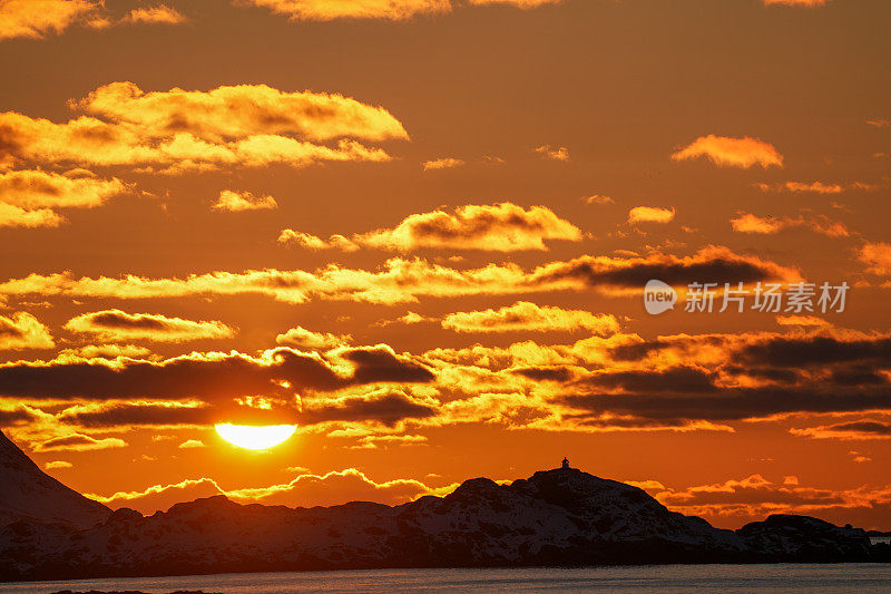傍晚的太阳躲在云层后面，落在挪威北部罗弗敦群岛上空。