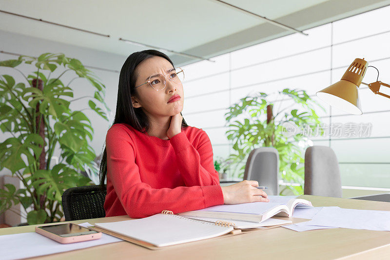 咖啡店里，女人用铅笔在笔记本上写字。在咖啡店户外工作的妇女。