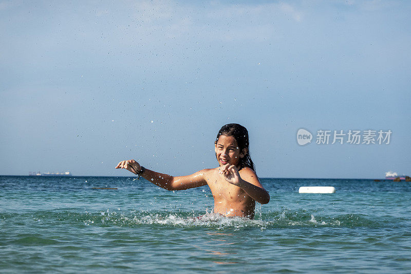 他用手在海里泼水。一个夏天的早晨。忒涅多斯岛。爱琴海北部，12岁的帅哥。长头发的