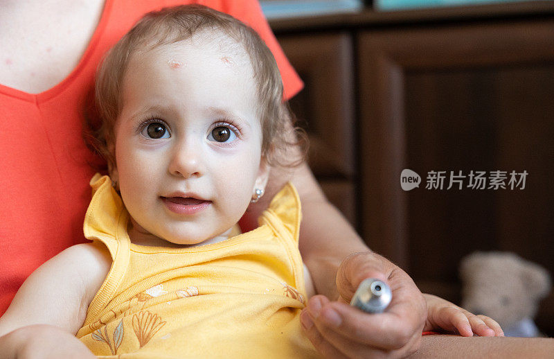 一个小女孩的肖像，她的额头上被蚊子咬起了水泡。