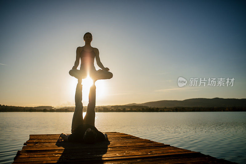 一男一女在湖边做杂技瑜伽