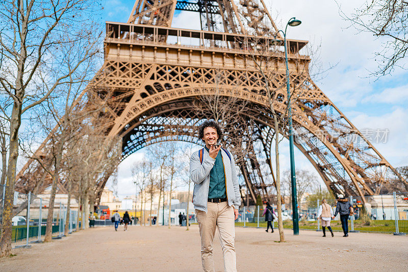 法国巴黎，一个年轻人在埃菲尔铁塔前发语音信息