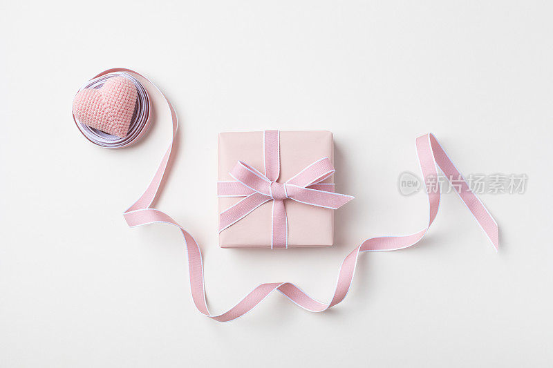 节日概念贺卡的生日，妇女或母亲节。粉红色的心，丝带和礼盒俯视图。
