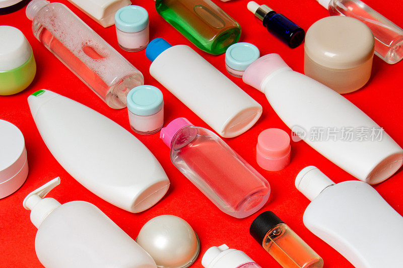 一组塑料护身瓶，用彩妆品平铺构图，在彩色背景上留白供您设计。一套白色化妆品容器，顶部视图与复制空间