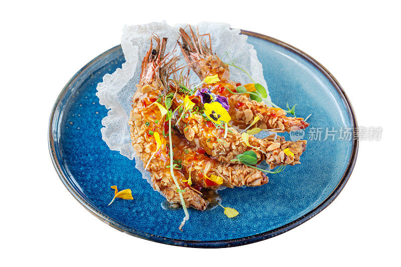 异国海菜老虎鱿鱼虾炒花生在一个盘子里装饰着鲜花。在一个白色孤立的背景上。