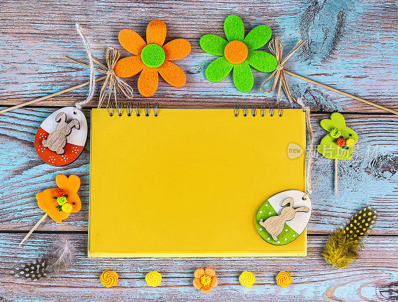 复活节卡片上有黄色和绿色的复活节彩蛋，装饰花，黄色的纸和笔