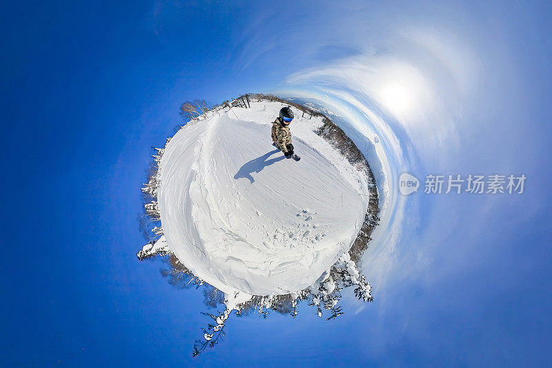 一个人在一个阳光明媚的日子里在一个“小雪星球”上滑雪