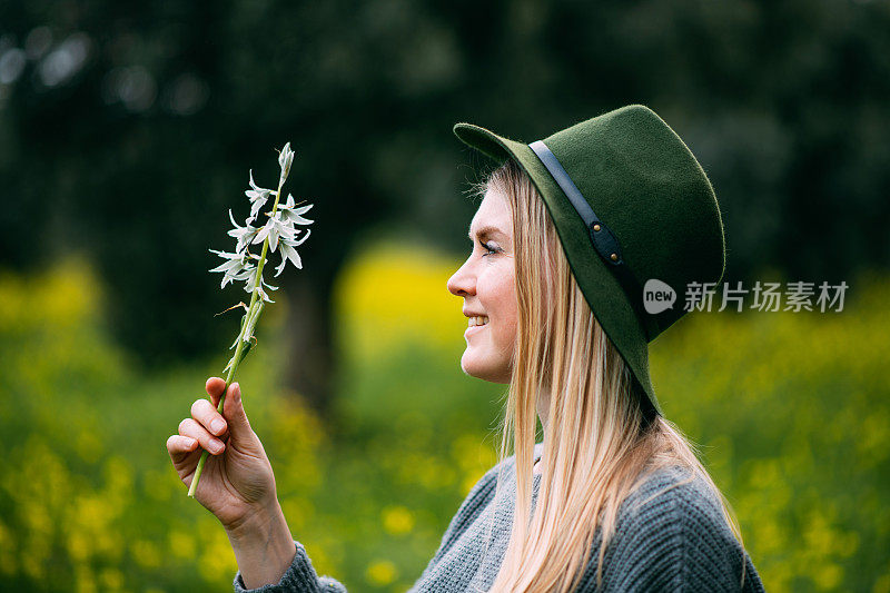 美丽的年轻女子手持春天的花朵