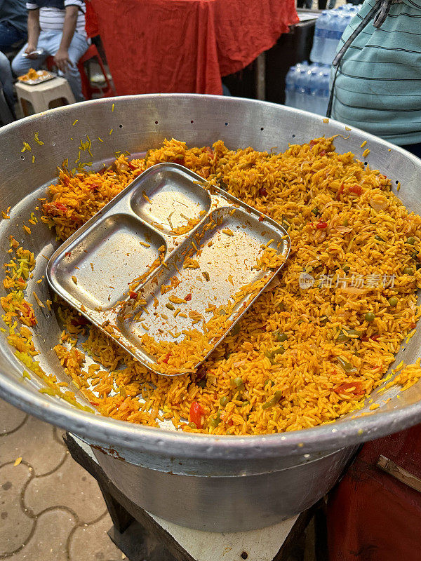 大锅烹制的蔬菜香辣饭的混合米饭的特写图像，印度街头小吃小贩，印度街头小吃摊位，不健康的饮食，高视图，关注前景